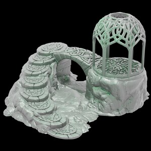 Pu&ograve; includere: Una miniatura stampata in 3D di un ponte di pietra con un arco di pietra e gradini che conducono ad esso. Un gazebo in pietra con un tetto a graticcio si trova su uno scoglio accanto al ponte. La miniatura &egrave; dipinta di un colore verde chiaro.