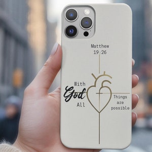 May include: White iPhone case with a gold heart and cross design. The text "With God All Things Are Possible" and "Matthew 19:26" are printed on the case.