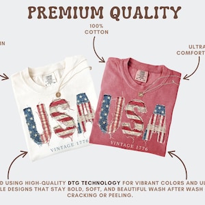 Puede incluir: Se muestran dos camisetas, una crema y otra roja. Cada una presenta la palabra "USA" en un dise&ntilde;o de bandera estadounidense desgastada, con "VINTAGE 1776" debajo. Las camisetas son 100% algod&oacute;n y se describen como ultra c&oacute;modas.