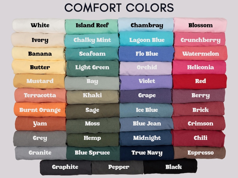 May include: A color chart displaying a variety of fabric colors, including white, ivory, and black. The text "COMFORT COLORS" is at the top. Each color is labeled with its name, such as "Island Reef," "Chambray," and "Blossom."