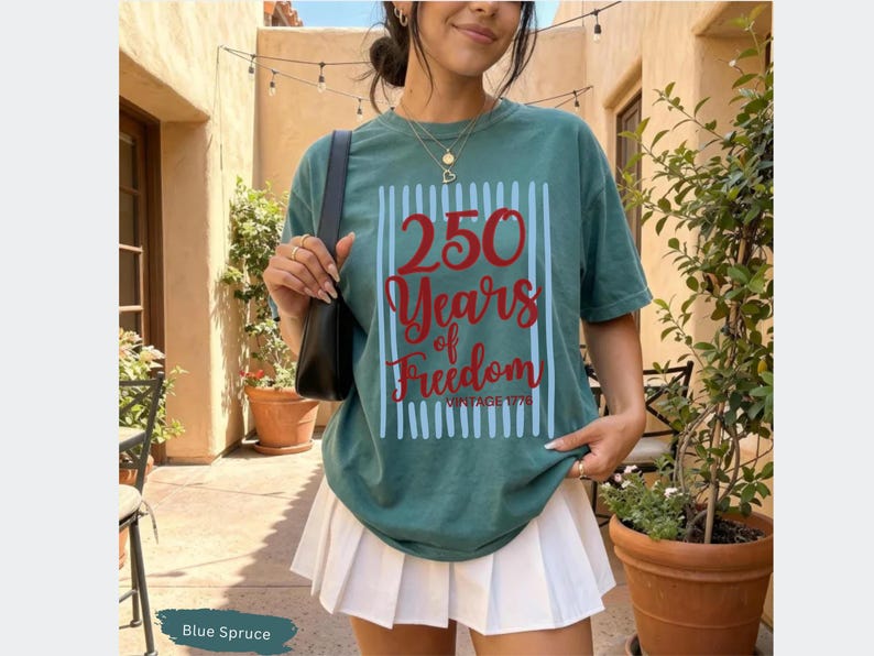 Woman wearing blue spruce Comfort Colors patriotic shirt featuring “250 Years of Freedom Vintage 1776” retro red and blue design for Fourth of July celebration