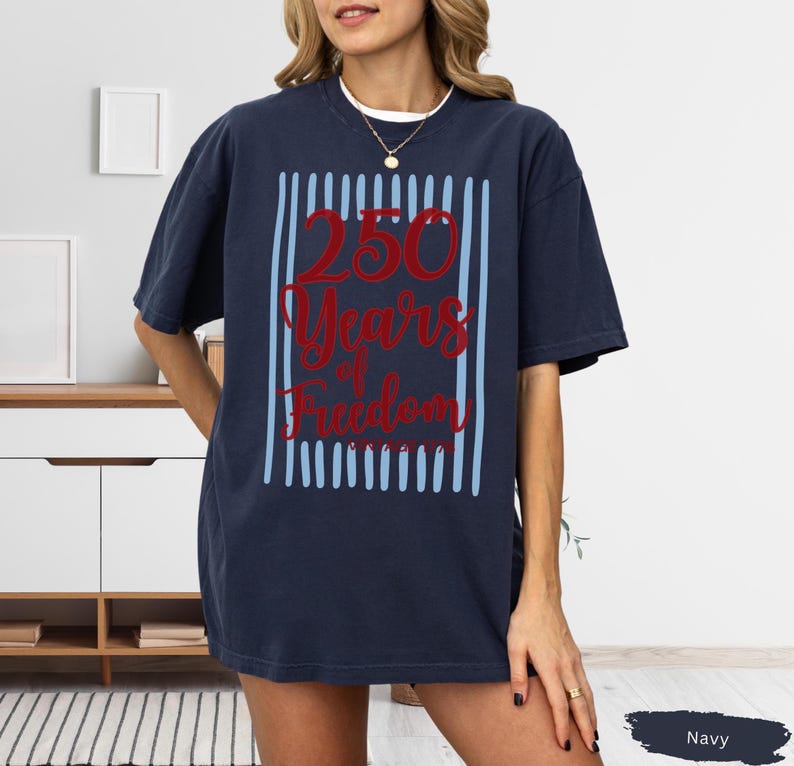 Woman wearing navy Comfort Colors patriotic shirt featuring “250 Years of Freedom Vintage 1776” retro red and blue design for Fourth of July celebration