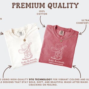 May include: Two t-shirts, one white and one red, are displayed. Each shirt features a cowboy hat and boot design with the text "Emily's Bachelorette Chicago Illinois." The shirts are made of 100% cotton and are printed in the USA.