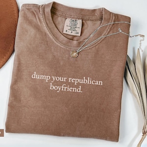 May include: Espresso brown t-shirt with the text "dump your republican boyfriend." printed in white.