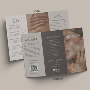 Op de afbeelding: Een brochure voor SKINAURA, een huidverzorgingssanctuary, wordt open weergegeven. De brochure bevat een prijslijst, servicebeschrijvingen en contactgegevens. De binnenkant toont afbeeldingen van handen en een close-up van een gezicht. De brochure is in grijstinten en beige.