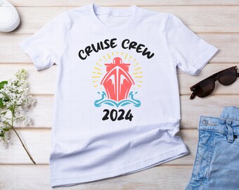 May include: White t-shirt with a graphic of a cruise ship and the text "Cruise Crew 2024".