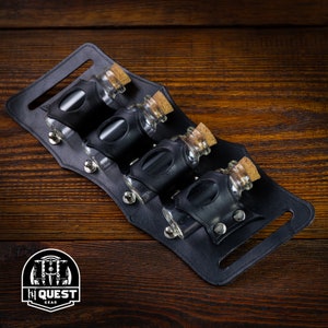 May include: Black leather potion belt with five glass vials with cork stoppers. The belt has a buckle and is designed to hold small bottles.