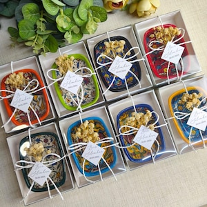 May include: A set of three ceramic mugs with a speckled, matte finish. The mugs are in shades of cream, light gray, and dark gray. Each mug has a simple, modern design and a rounded handle.