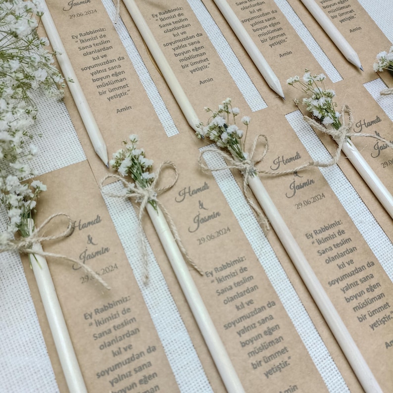 Może przedstawiać: Biały ceramiczny kubek z czarnym uchwytem i napisem "But First, Coffee" pogrubioną czcionką. Kubek jest umieszczony na rozmytym tle, sugerującym przytulne otoczenie.