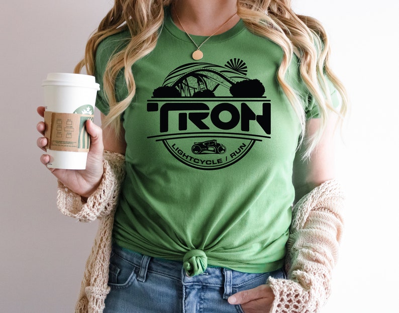 May include: Green t-shirt with a black circle graphic featuring the word "TRON", a lightcycle, and the text "LIGHTCYCLE / RUN".