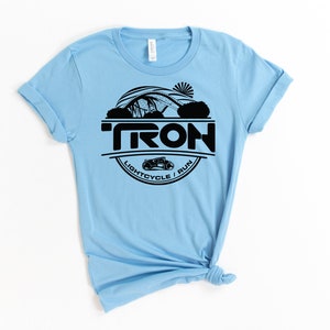May include: Light blue t-shirt with a black graphic of a Tron lightcycle and the text "TRON LIGHTCYCLE / RUN".