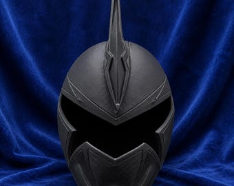May include: A matte black helmet featuring a prominent central vertical fin extending from the forehead. The helmet has a wide, dark, open visor area and angular, geometric molded details across the surface, creating a sleek, uniform appearance.