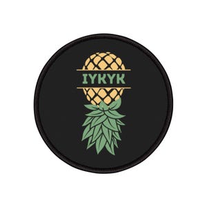 Puede incluir: Parche redondo negro con un diseño de piña estilizada. La piña es amarilla y verde, con el texto "IYKYK" en letras verdes. El parche tiene un borde negro y es probablemente un parche termoadhesivo o para coser.