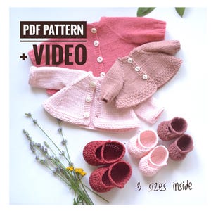 May include: A selection of hand-knitted baby clothes in shades of pink. The image shows three cardigans and three pairs of baby shoes. Text includes "PDF PATTERN + VIDEO" and "3 sizes inside".