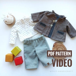 Op de afbeelding: Een PDF-patroon en een video-tutorial voor het naaien van een poppenoutfit. De outfit bestaat uit een wit shirt met een bloemenprint, een bruin jasje met een zwarte stippenvoering en een groene broek. De tekst "PDF PATTERN + VIDEO" is zichtbaar in de afbeelding.