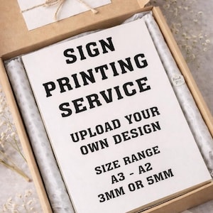 May include: A cardboard box containing a printed sign service. The sign reads "SIGN PRINTING SERVICE, UPLOAD YOUR OWN DESIGN, SIZE RANGE A3 - A2, 3MM OR 5MM." Includes a small card that says "Thank you".
