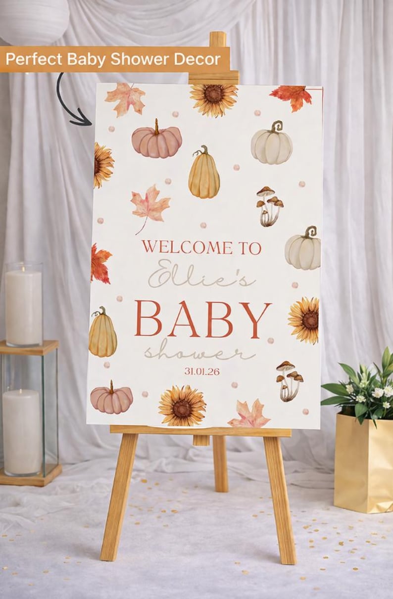 May include: A baby shower sign on a wooden easel. The sign features watercolor illustrations of pumpkins, sunflowers, and leaves. Text reads "Welcome to Ellie's BABY shower 31.01.26". The sign is decorated with fall-themed elements.