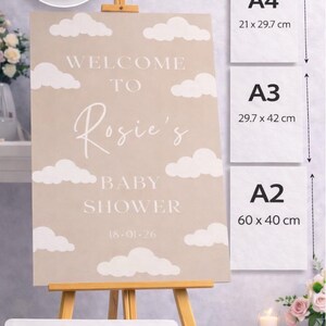 Op de afbeelding: Een beige foam board bord met de tekst "Welcome to Rosie's Baby Shower" en de datum 18-01-26. Beschikbare maten zijn A4 (21 x 29,7 cm), A3 (29,7 x 42 cm) en A2 (60 x 40 cm).