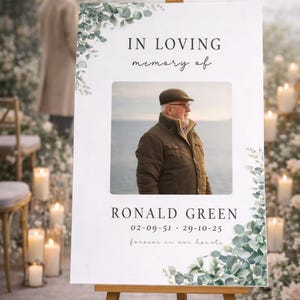 Peut inclure: Panneau comm&eacute;moratif sur chevalet en bois. Le panneau indique &laquo;&nbsp;&Agrave; la m&eacute;moire affectueuse de&nbsp;&raquo; au-dessus d'une photo d'un homme. Sous la photo se trouvent le nom &laquo;&nbsp;RONALD GREEN&nbsp;&raquo; et des dates. De la verdure et des bougies entourent le panneau.
