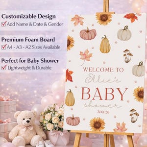 May include: A custom baby shower welcome sign on an easel. The sign features watercolor pumpkins, sunflowers, and leaves. Text includes "Welcome to Ellie's Baby Shower" and "31.01.26". The sign is customizable and made of premium foam board.