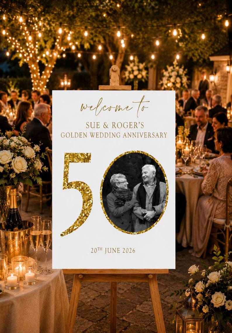May include: A white sign on a wooden easel with gold text that reads "welcome to" and "SUE & ROGER'S GOLDEN WEDDING ANNIVERSARY". A photo of a couple is in a gold circle, with a large gold "50" and the date "20th JUNE 2026".