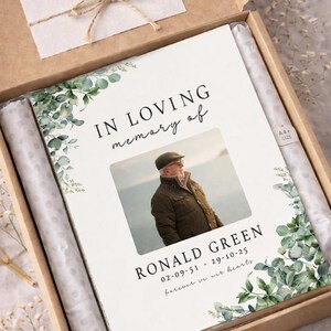 Peut inclure: Album photo de deuil de format A4 dans une bo&icirc;te en carton kraft. La couverture de l'album indique &laquo; IN LOVING memory of &raquo; et pr&eacute;sente une photo, un nom et des dates. La bo&icirc;te comprend une carte &laquo; Merci &raquo;.