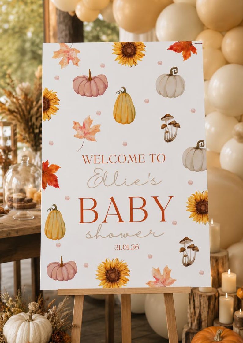 May include: A white welcome sign on an easel, decorated with watercolor pumpkins, sunflowers, and fall leaves. The sign reads "Welcome to Ellie's Baby Shower 31.01.26" in a mix of fonts and colors, perfect for a fall-themed baby shower.
