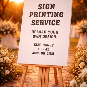 May include: A white sign on a wooden easel, displaying "SIGN PRINTING SERVICE" and "UPLOAD YOUR OWN DESIGN." The size range is A3-A2, with options for 3mm or 5mm thickness. The background features flowers and a warm, golden light.