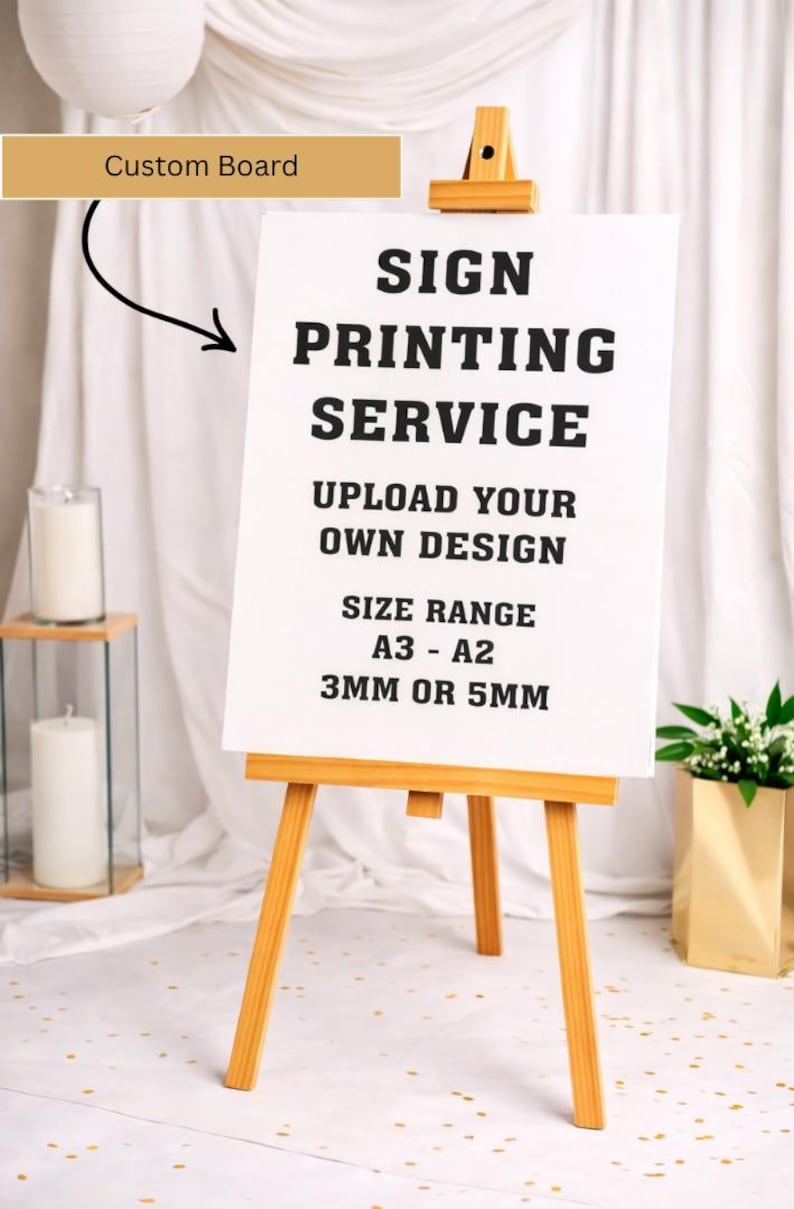 May include: A white sign on a wooden easel, advertising a sign printing service. The sign reads "SIGN PRINTING SERVICE, UPLOAD YOUR OWN DESIGN, SIZE RANGE A3 - A2, 3MM OR 5MM". A gold-colored "Custom Board" label is above the sign.