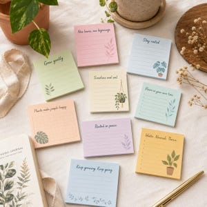 Puede incluir: Un conjunto de notas adhesivas coloridas con ilustraciones botánicas y frases inspiradoras como "Sunshine and soil" y "Keep growing. Keep going." Las notas están dispuestas sobre una superficie clara, con un diario y un bolígrafo.