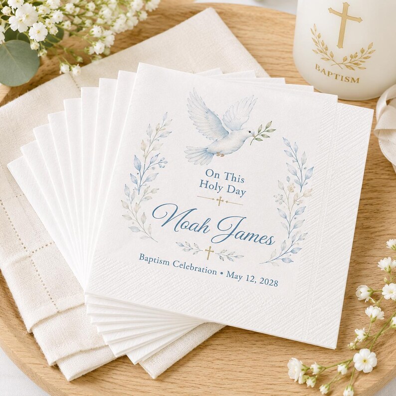 Puede incluir: Una pila de servilletas de papel blanco con una paloma en acuarela azul, ramas con hojas y cruces doradas. El texto dice: On This Holy Day, Noah James, Baptism Celebration, May 12, 2028. Las servilletas tienen un borde texturizado y forma cuadrada.
