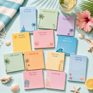 Peut inclure: Un ensemble de blocs-notes colorés sur le thème de la plage. Chaque note présente une phrase différente comme "Laissez la mer vous libérer" et des illustrations de palmiers, de coquillages et de vagues.