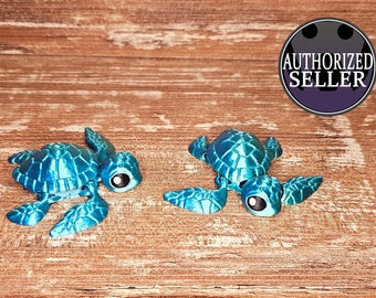 May include: Two small, teal-colored turtle figurines with large, black eyes. The turtles are positioned on a wooden surface.