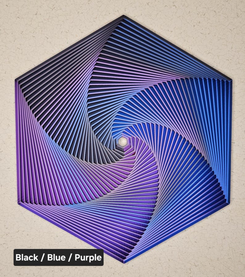 May include: A hexagonal wall art piece with a swirling pattern of black, blue, and purple stripes. The stripes create a hypnotic effect as they spiral inward.