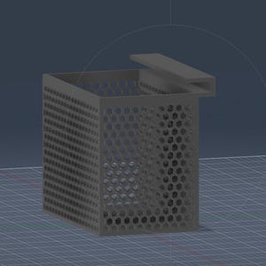May include: A gray, rectangular container with a perforated honeycomb pattern on the sides and a hinged lid. The container is designed with a modern aesthetic and sits on a grid-like surface.