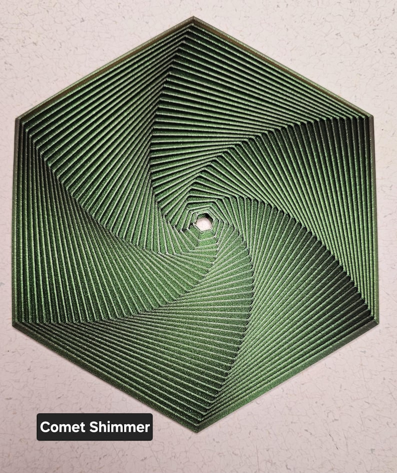 May include: A green hexagonal geometric design with a swirling pattern. The design has a metallic sheen and is called "Comet Shimmer".