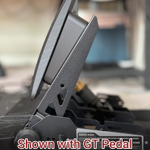 May include: A black metal racing seat with a black pedal spacer and cleats. The seat is shown with a black pedal that is raised up. The text "Shown with GT Pedal Cleats and Pedal Spacer" is visible in the image.