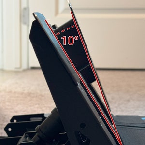 May include: A black metal desk stand with a 10-degree angle, designed to hold a laptop or tablet.