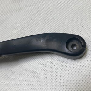 以下が含まれることがあります： 丸い穴が付いた黒いプラスチック製の車のワイパーアーム