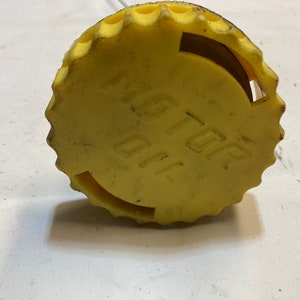 May include: Yellow plastic bottle cap with the words "TOP OIL" printed on it.