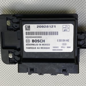 Puede incluir: Un módulo de control electrónico negro con el texto "GM 20928121", "0263004442C0000", "BOSCH", "ASSEMBLED IN MEXICO", "FABRIQUE AU MEXIQUE", "0 263 004 442", "864", "100922 PPL1 0060" y "6002JC0000" impreso en él.