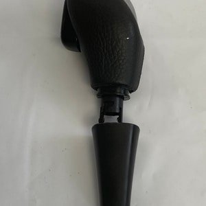 May include: Black leather gear shift knob with a silver top and a black plastic base.
