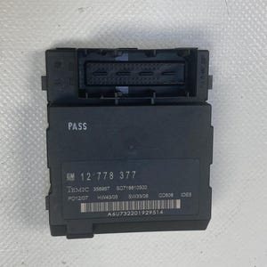 May include: A black electronic control module with a rectangular shape. The module has a connector at the top and a label with text including "PASS" and "GM 12 778 377". A barcode is also visible.