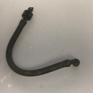 May include: A curved, black rubber hose with a connector at each end. One end has a larger, cylindrical connector with a small, black cap. The hose is slightly bent and appears to be a vehicle part.