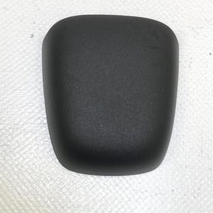 May include: A solid black, curved, rectangular object with rounded edges. The object has a slightly textured surface and appears to be made of a matte material. The shape is reminiscent of a small, padded component.