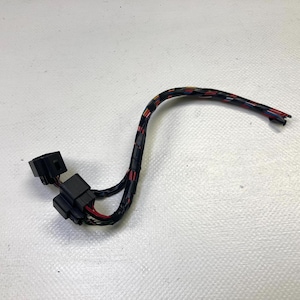 May include: A black electrical wiring harness with red and blue accent stripes. The harness has two black connectors and a flexible, insulated cable. The image is taken against a white background.
