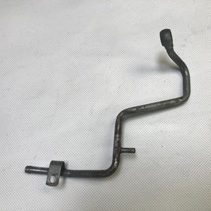 May include: A metal pipe with a bend in the middle and a rounded end. The pipe is rusty and has a few scratches.