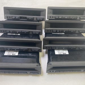 May include: Eight dark grey car radio display units are shown. Each unit has a rectangular shape with a screen and buttons labelled "CLEAR", "SET", and "NIGHT PANEL". The units are stacked in pairs.