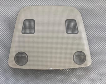 May include: A beige car interior light with two rectangular light fixtures and two round lights.