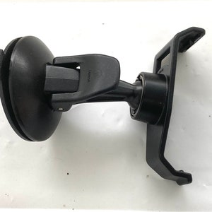 May include: Black car phone mount with a suction cup base and a swivel arm. The mount has a spring-loaded clip to hold the phone in place.